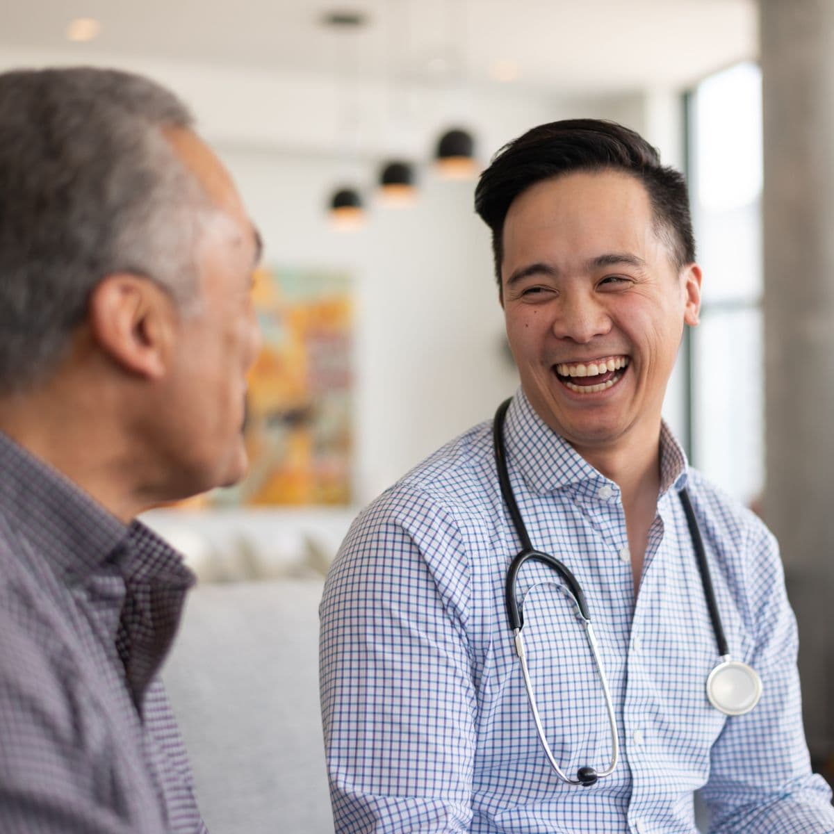 Male GP talking to elderly patient
